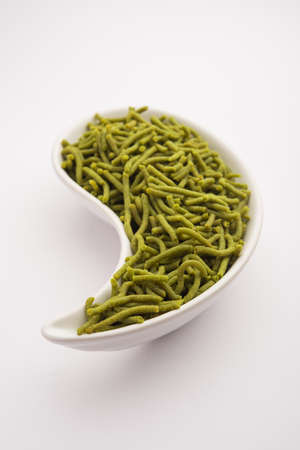 Spinach or palak sev are crunchy fried savory noodles. Homemade Thick and thin greenÂ shev or namkeen is a classic Indian snack. served in a bowl or plateの写真素材