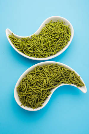 Spinach or palak sev are crunchy fried savory noodles. Homemade Thick and thin greenÂ shev or namkeen is a classic Indian snack. served in a bowl or plateの写真素材