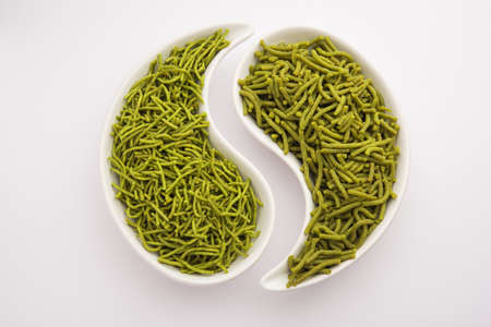 Spinach or palak sev are crunchy fried savory noodles. Homemade Thick and thin greenÂ shev or namkeen is a classic Indian snack. served in a bowl or plateの写真素材