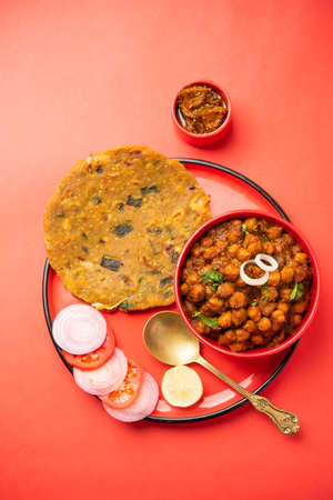Spicy chickpea masala or chole curry with Pyaj Paratha or Spring Onion Parantha and mango pickle