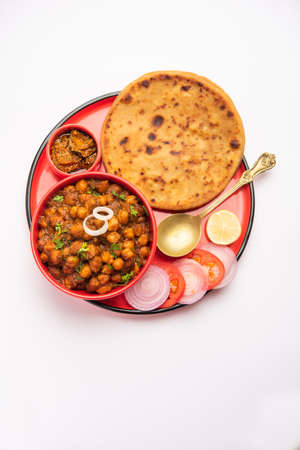 Chole with Aloo Paratha or Alu parantha, popular north Indian food recipe served hot with mango...