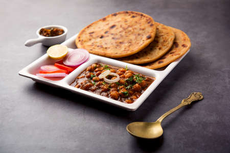 Chole with Aloo Paratha or Alu parantha, popular north Indian food recipe served hot with mango pickleの写真素材
