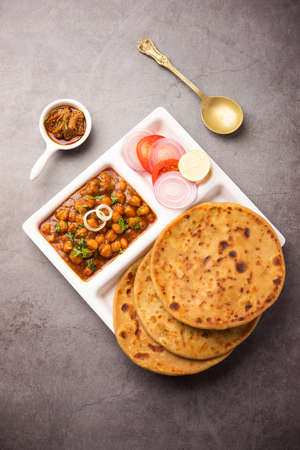 Chole with Aloo Paratha or Alu parantha, popular north Indian food recipe served hot with mango...