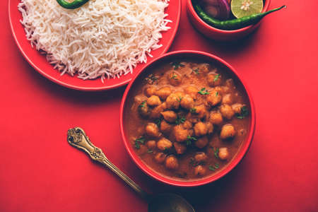 Indian food chole chawal or spicy Chickpea curry with plain rice served with green salad. selective...