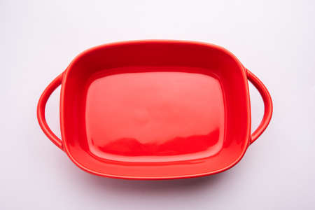 Empty red ceramic serving bowl, isolated over white or gray backgroundの写真素材
