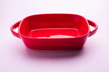 Empty red ceramic serving bowl, isolated over white or gray backgroundの写真素材
