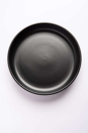 Empty black ceramic serving bowl, isolated over white or gray backgroundの写真素材