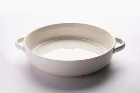 Empty white ceramic serving bowl, isolated over white or gray backgroundの写真素材
