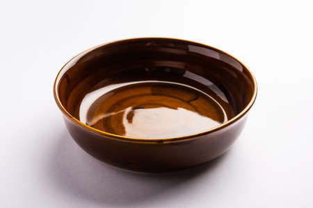 Empty brown ceramic serving bowl, isolated over white or gray backgroundの写真素材