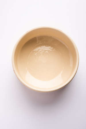 Empty brown ceramic serving bowl, isolated over white or gray backgroundの写真素材