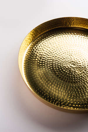 Empty oval or round shape thali or plate made up of brass, pital or gold over white backgroundの写真素材