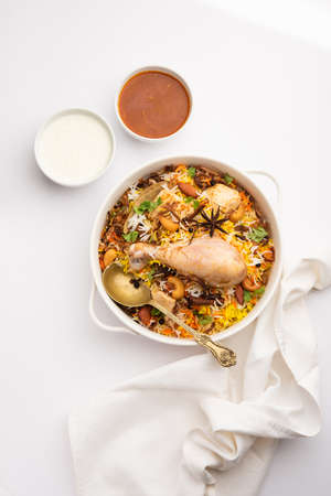 Restaurant style Spicy Chicken Biryani served with Raita and Salan, Popular Indian or Pakistani non...