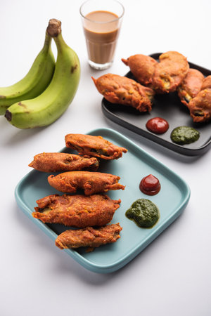 Banana Fritter or pakora or raw kela pakodaÂ or bajji served with chutney. Popular snack from Kerala, India or Indonesia. served with teaの写真素材