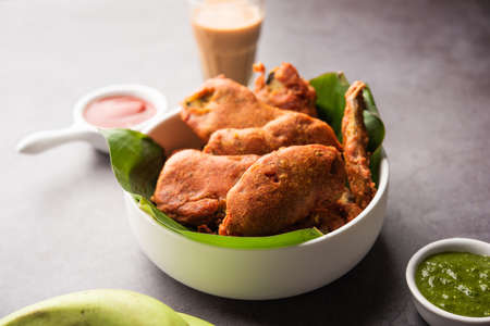 Banana Fritter or pakora or raw kela pakodaÂ or bajji served with chutney. Popular snack from...