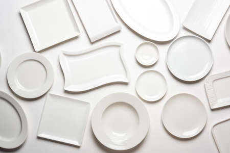 different shape white plates isolated on white background, top viewの写真素材