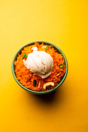 Galar Halwa with Vanilla Ice cream, served in a bowl and garnished with dry fruits. selective focusの写真素材