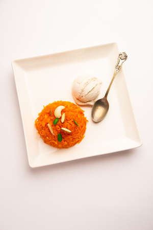 Galar Halwa with Vanilla Ice cream, served in a bowl and garnished with dry fruits. selective focusの写真素材
