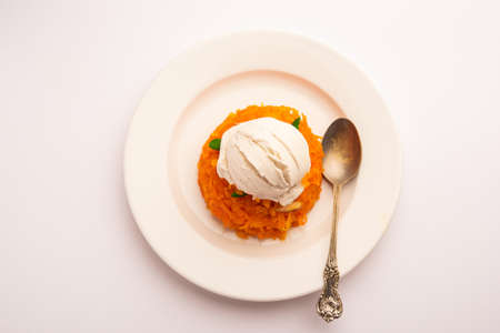 Galar Halwa with Vanilla Ice cream, served in a bowl and garnished with dry fruits. selective focusの写真素材