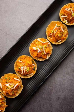 Carrot or Gajar Halwa canape or canapÃ© or Fusion Tart, garnished with dry fruits. Indian dessertの写真素材