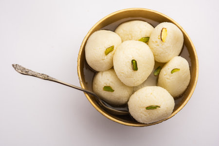 Rasgulla or rosogulla - an Indian sweet made from khoya, soft and spongy, in earthen bowl over...