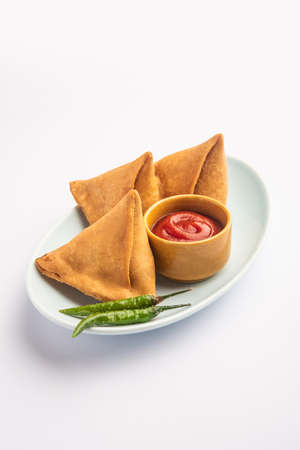 Veg Samosa - is a crispy and spicy Indian triangle shape snack which has crisp outer layer of maida & filling of mashed potato, peas and spicesの写真素材