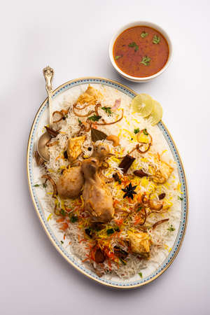 Indian Chicken Biryani served in a terracotta bowl with yogurt over white background. selective focusの写真素材