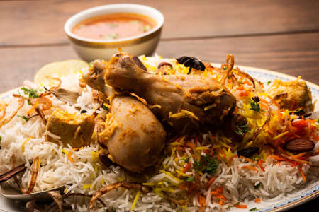 Indian Chicken Biryani served in a terracotta bowl with yogurt over white background. selective focusの写真素材