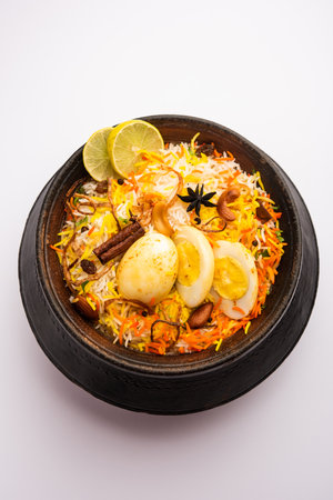 Egg Biryani - Basmati rice cooked with masala roasted eggs and spices and served with yogurt, selective focusの写真素材