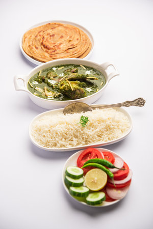 Palak Gosht or mutton curry, Indian style spinach and lamb curry served with rice and laccha paratha