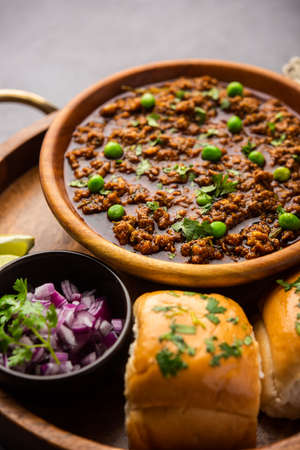 Mutton Kheema Pav OR Indian Spicy Minced Meat served with bread OR kulcha, garnished with green...