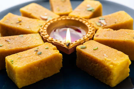 Mysore Pak and diwali diya or clay lamp decorated in a plate - Happy Diwali Greetingの写真素材