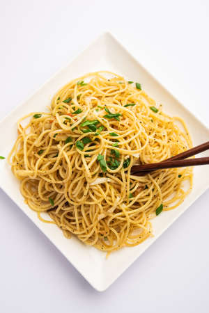 Schezwan Noodles or Szechwan vegetable Hakka Noodles or chow mein is a popular Indo-Chinese recipes, served in a bowl or plate with wooden chopsticksの写真素材