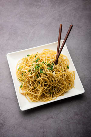 Schezwan Noodles or Szechwan vegetable Hakka Noodles or chow mein is a popular Indo-Chinese recipes, served in a bowl or plate with wooden chopsticksの写真素材