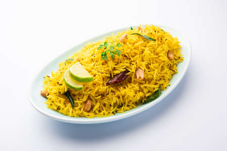 Lemon rice with curry leaf, peanuts and red chilly, served in a ceramic bowl, selective focusの写真素材