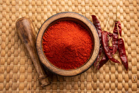 Red Chilli or Lal Mirchi or mirch with Powder in a bowl or mortar over moody background, selective...