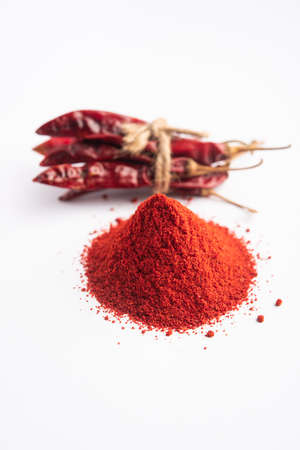 Red Chilli or Lal Mirchi or mirch with Powder in a bowl or mortar over moody background, selective...