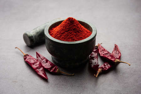 Red Chilli or Lal Mirchi or mirch with Powder in a bowl or mortar over moody background, selective focusの写真素材