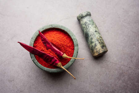 Red Chilli or Lal Mirchi or mirch with Powder in a bowl or mortar over moody background, selective focusの写真素材