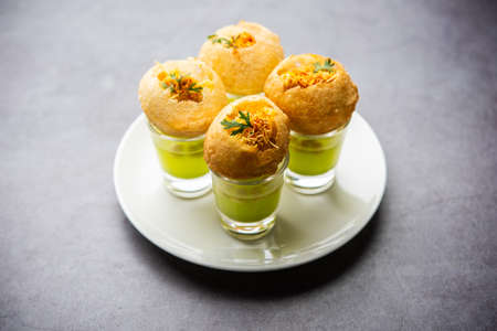 Panipuri shot or Golgappa Shots, different flavours of water served in small glasses with stuffed...