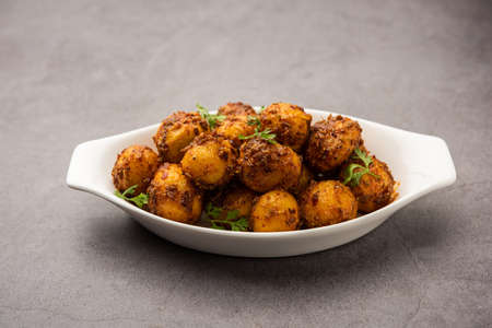 Homemade Roasted Bombay potatoes. Pan fried little baby potatoes or aloo with jeera seeds and coriander in bowlの写真素材