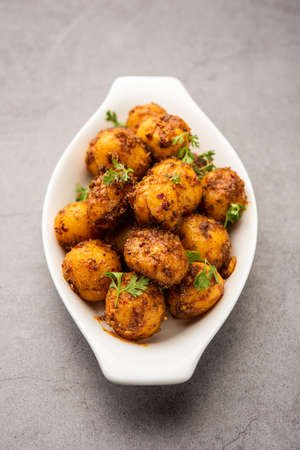 Homemade Roasted Bombay potatoes. Pan fried little baby potatoes or aloo with jeera seeds and coriander in bowlの写真素材