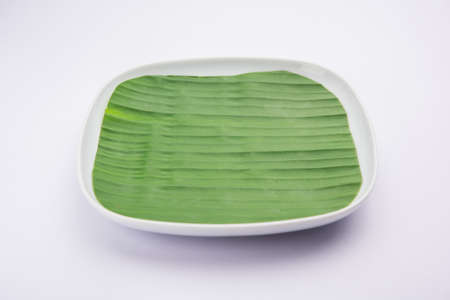 banana leaf on blank plate for edit food or subject on