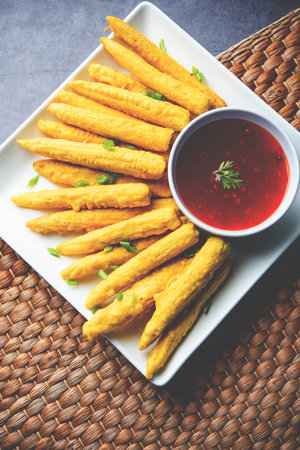 Crispy fried baby corn pakoda, pakora  or Baby corn fritters served with ketchup, Indian food