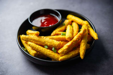 Crispy fried baby corn pakoda, pakora  or Baby corn fritters served with ketchup, Indian foodの写真素材