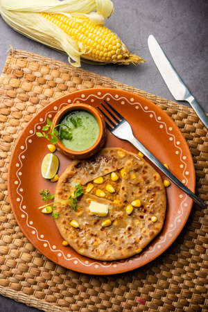 Sweet corn stuffed paratha or parotha served in a plate, Indian flatbread recipe made filling makai