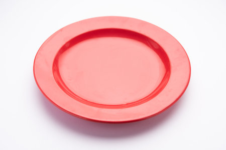 Empty Red ceramic plate isolated over white background