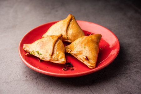 Indian sweet samosa is a Fried pastry soaked in sugar syrup filled with coconut, nuts and fruitsの写真素材