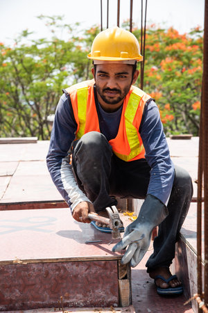 Indian asian malIndian asian male construction worker on site using nail with hammer preparing frame for slabe construction worker on site using nail with hammer preparing for slabの写真素材