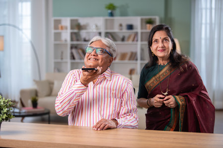 Indian retired senior couple using smartphone at homeの写真素材
