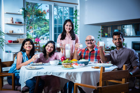 Happy multi-generation asian Indian family enjoying lunch together at home.の写真素材